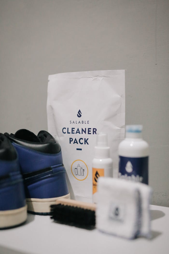 A comprehensive sneaker cleaning kit featuring a brush, cloth, and cleaning products for shoe care.